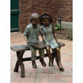 bronze boy and girl sitting on bench sculpture